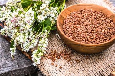 Ahşap tabakta kurutulmamış karabuğday. Çiğ yiyecekler ve vejetaryenler için yiyecek. Kilo vermek için sağlıklı yiyecekler. Yumuşak odak