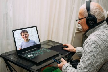 Büyükbaba torunla haberci aracılığıyla iletişim kuruyor, monitör ekranına bakıyor..