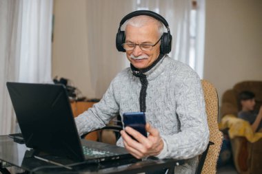 Sosyal medya teknolojisi kullanan gülen yaşlı adam heyecanlanıyor