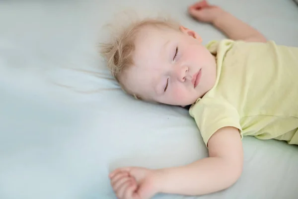 Małe Dziecko Śpi Wyciągniętymi Ramionami Dziewczyna Blond Włosami Żółtym Body — Zdjęcie stockowe