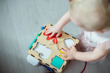 Bir kedi, bir ayı, bir daire, tahta ayırıcıdaki bir yıldız figürü. Çocuk, ırkların pratik becerilerini geliştirmek için oyuncak üniformalarını doğru şekilde seçti.