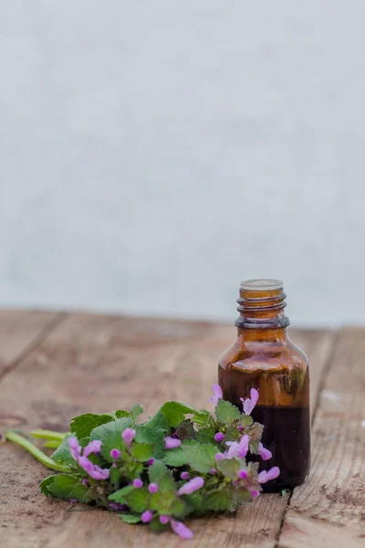 pharmaceutical bottle of medicine from Thymus vulgaris, common thyme, German, garden or just thyme on a wooden table. Preparation of medicinal plants. Ready potion of grass. Ethnoscience.