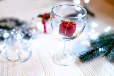 Noel ya da yeni yıl için şeffaf bir bardakta küçük kırmızı bir sürpriz hediye.