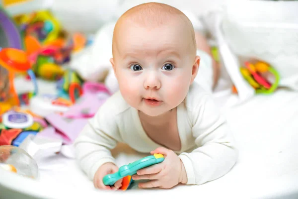 Ένα Αστείο Μωρό Άσπρα Ρούχα Ξαπλώνει Μια Κούνια Κοντά Παιχνίδια — Φωτογραφία Αρχείου