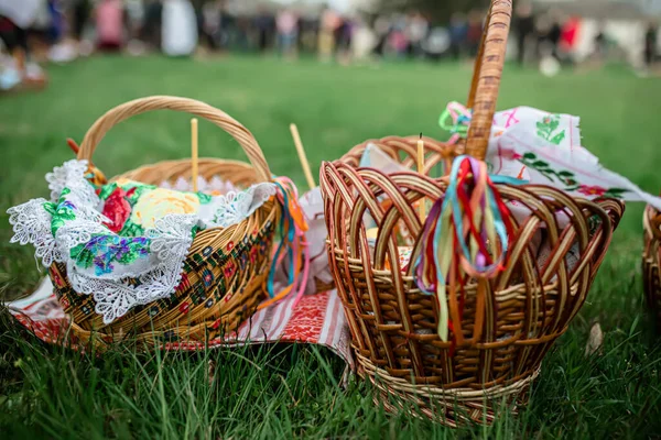 Easter baskets on the grass during the liturgy for Orthodox Easter. Consecration of Easter cakes and eggs with holy water