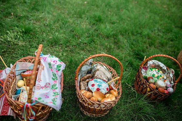 Easter baskets on the grass during the liturgy for Orthodox Easter. Consecration of Easter cakes and eggs with holy water