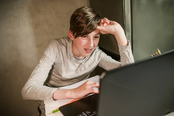 student answers the teachers question while studying online on a laptop. Childs hand on the touchpad. Web tutor gives remote class teaching teenage pupil elearning from home.