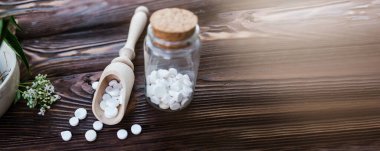 Sakinleştirici özelliği olan Valerian hapları. Ahşap bir masanın üzerinde haplar olan ecza kavanozu. Herbalizm İksiri için havanda Valerian Kökü pişirmek. Tıbbi afiş, yumuşak odaklanma