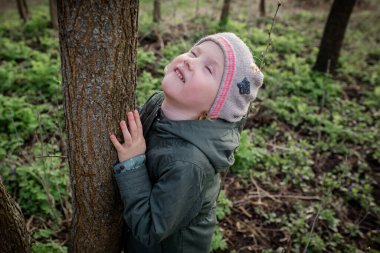 Ağaca sarılmak: kız sakin ve uyumlu hissediyor, ruh ağacı terapisi kavramını canlandıran ve canlandıran orman terapisinin tadını çıkarıyor, Shinrin-yoku.