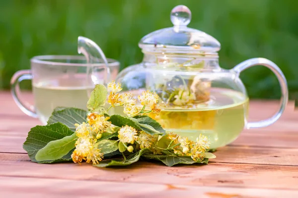 stock image cup of hot linden tea with honey and linden flowers on wooden table in garden. golden color of tea and sweetness of honey and flower delicious and soothing drink