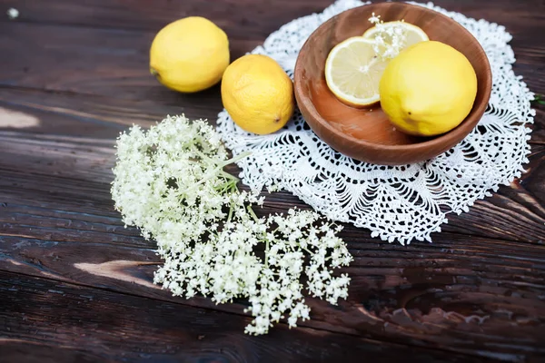 Spiritual travels with a book of self-care spells with recipes for spa salons made of elderberry juice. Elderberry flowers on a white wooden background near a vintage book.