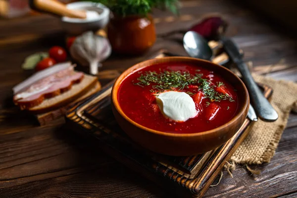 Geleneksel Ukrayna çorbası. Bir kase kırmızı pancar kökü çorbası ve beyaz krema. Pancar kökü çorbası. Geleneksel Ukrayna mutfağı.