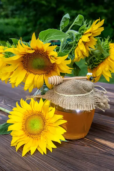 Sweet honey from sunflower. Fresh flower sunflower in wooden table.