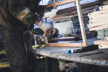 Öğütme makinesi olan adam arılar için çerçeve yapar. Kendi ellerinizle arı çerçevesi oluşturun.