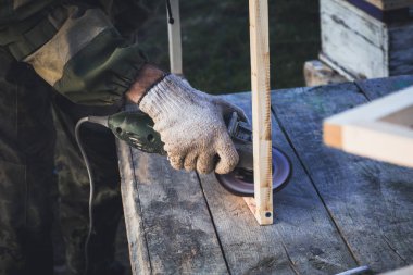 Öğütme makinesi olan adam arılar için çerçeve yapar. Kendi ellerinizle arı çerçevesi oluşturun.