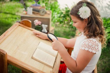 Mutlu İlkokul Kızı büyüteçle doğayı kavrayıp inceliyor. Soğuk algınlığını önlemek için dışarıda öğreniyorum. Walfdorf Okulu. Çevre dostu öğrenme. Okul temalı yaratıcı konsept