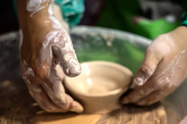 child eagerly practices pottery, striving to craft a perfect plate.