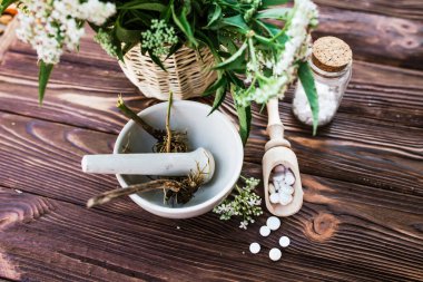 Valerian tablets with sedative properties. Pharmaceutical jar with pills on a wooden table. Cooking Valerian Root in a Mortar for Herbalism Elixirs. Soft focus