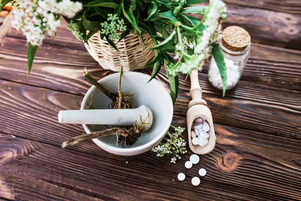 Valerian tablets with sedative properties. Pharmaceutical jar with pills on a wooden table. Cooking Valerian Root in a Mortar for Herbalism Elixirs. Soft focus