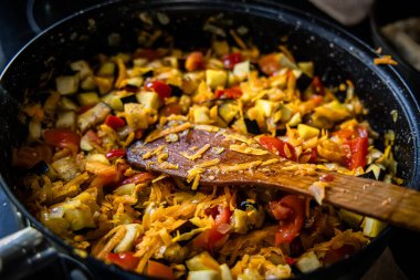 Bir şef tavada ratatouille pişirirken gurme lezzeti ustalıkla şekilleniyor. Ocakta patlıcanlı ragu var..