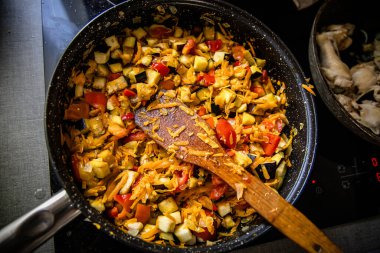 Şef aşçılık uzmanlığı sergileniyor, nefis bir ratatouille salatası hazırlıyorlar. Ocakta patlıcanlı ragu var. Üst görünüm