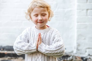 Ağırbaşlılık anında, genç olan başını eğiyor ve ellerini dua etmek için çırpıyor..