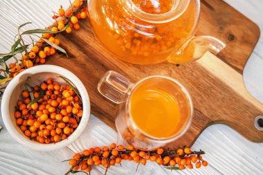 Deniz dikenli çay ile berrak çaydanlık, aroma karışımı ve sağlık faydaları. Deniz dikenli çay, lezzetli ve tıbbi bir içecek.