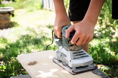 Ahşap işçisi elektrikli bir planörle bir tahta uçuruyor. Elektrik Planlayıcısı Eylemde
