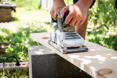 Elektrik Planörü devrede. Ahşap bir tahtanın dokusunu elektrikli bir aletle mükemmelleştiriyor.