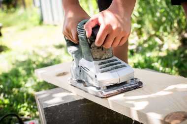 Tahta döşemeyi elektrikli planörle düzleştirme konusunda uzmandır.