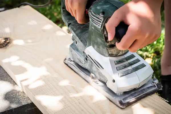 Precision in action as a power planer refines a wooden surface Electric planer in the hands of a craftsman