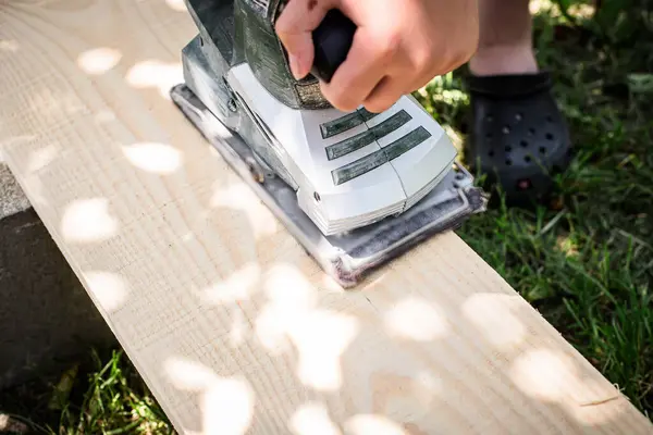 Electric Planer in Action. Professional carpenter shaping wood with an electric hand planer