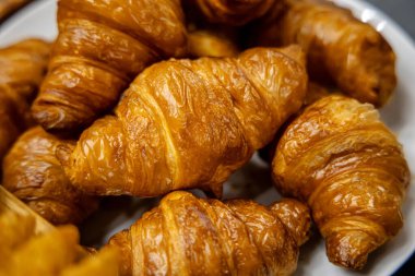 Masadaki beyaz tabakta taze kruvasan.