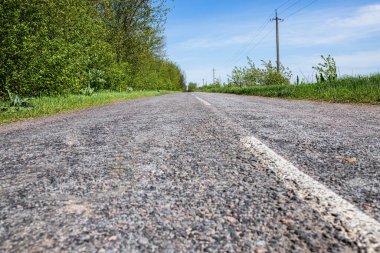 Ortalama şeritli bir yol. Boş asfalt yol ve mavi gökyüzü