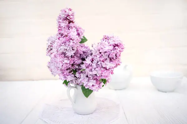 Creative still life. Delicate bouquet of lilacs in a vase. Spring concept.