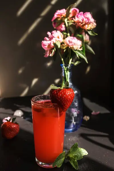 creative and colorful fruit strawberry and mint punch. Barista adds fresh mint in glass on party or celebration,