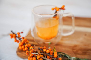 Masada deniz dikeninden yapılmış güzel kokulu vitamin çayı var. Daldaki taze deniz dikenli üzümleri iyileştirme içeceği için hazırlar..