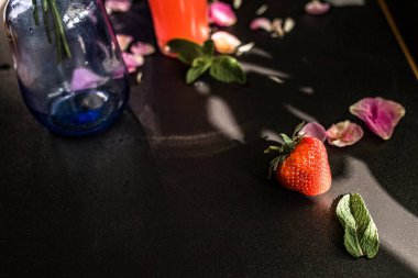 Strawberry with mint leaves on a black background clipart