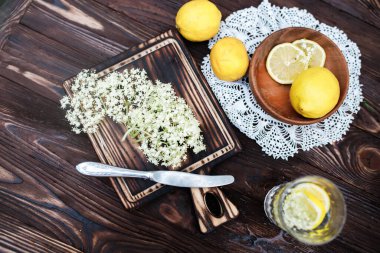 Kesme tahtasındaki limon ve böğürtlen ezmesi. Bitkisel bir içecek yapmak için. Ya da mürver çiçeklerinin şerbetinden evde şifa bulmak için..