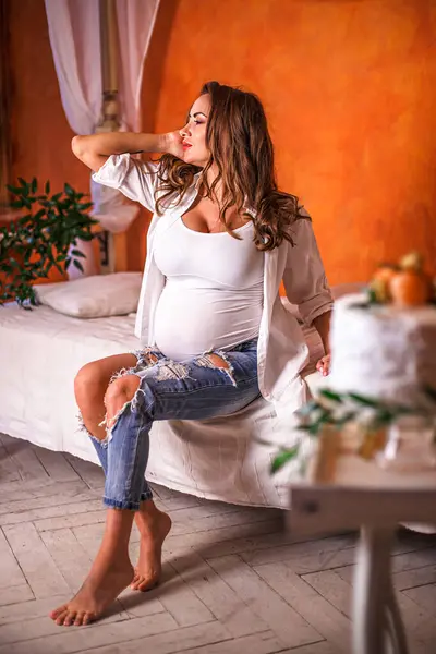 Beautiful pregnant woman in orange room during celebration. Celebration of new beginnings..
