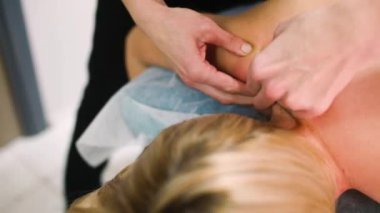 Masör güzellik salonunda kadınlara masaj yapıyor.