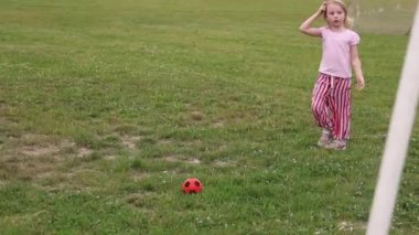 Kız sahada top oynuyor, futbol oynuyor.