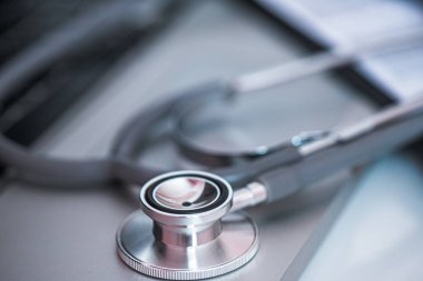 Bir bilgisayar klavyesindeki steteskopun yakın çekimi, bilişim teknolojisinin tıbbi uygulamalara entegrasyonunu gösteriyor. Tıp konseptinde bilgi teknolojisi