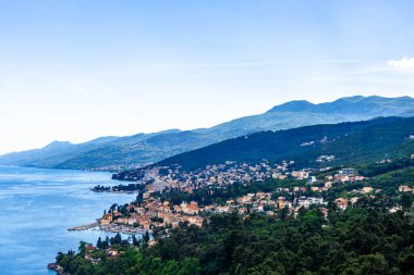 Hırvatistan 'ın Opatija kentinin panoramik manzarası, Adriyatik kıyı şeridini gözler önüne seriyor, yemyeşil tepeler ve masmavi deniz arasında kurulmuş büyüleyici bir kasaba..