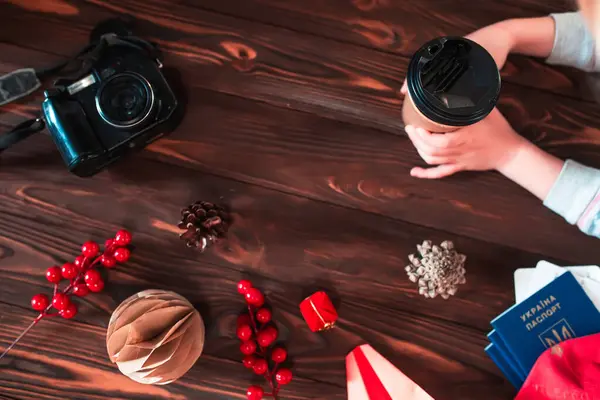 stock image A person enjoys a warm beverage while surrounded by festive decorations, including soybeans, pinecones, and colorful wrapped gifts.