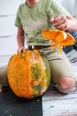 Cadılar Bayramı için balkabağı oymak. Cadılar Bayramı çocuğuna hazırlanmak, balkabağının tepesini çıkarır. Balkabağı kabağına korkunç bir yüz çizmek için oyulmuştur. Adım adım. Adım 2