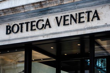 Venedik, İtalya, 17 Ağustos 2024: Mağaza vitrininde, modern moda ürünleri sergilenen, büyük cam pencereli zarif bir tasarım olan Bottega Veneta yer alıyor. Marka adı yukarıda belirgin bir şekilde gösterilir, yoldan geçenleri çizer.