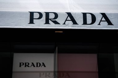 Venedik, İtalya, 17 Ağustos 2024: Mağaza vitrininde, lüks bir alışveriş bölgesinde lüks moda cazibesini vurgulayan, Prada marka adının kalın harflerle sergilendiği minimalist bir tasarım yer almaktadır.: