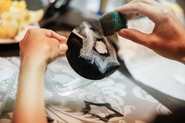 Cristmas Craft Hands siyah bir maddenin üzerinde bir yıldız şekli yaratmak için bir sünger uyguluyor. Detaylara ve sanatsal ifadeye odaklanmış yaratıcı bir zanaat süreci sergiliyor..