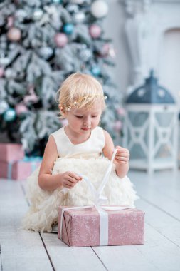 Küçük bir kızın modern bir Noel ağacını ihtimam ve heyecanla süslemesi gibi parlak, zarif bir oturma odası büyülü hale gelir..